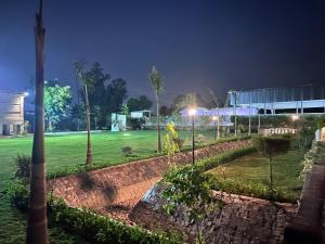 a park at night with trees and a building at Singhal's Farm House in Greater Noida