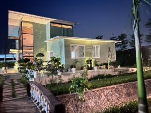 a green house with a fence in front of it at Singhal's Farm House in Greater Noida