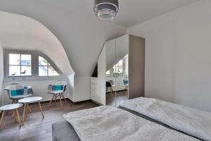 a bedroom with a bed and chairs and a staircase at FH Wiesenkieker in Güstow