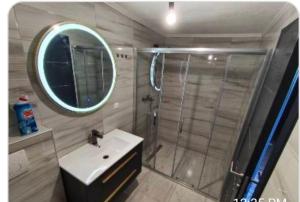 a bathroom with a shower and a sink and a mirror at Apartman Florida ranč in Doboj +8 photos
