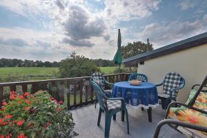 a patio with a table and chairs on a balcony at FeWo Geranie in Kröpelin