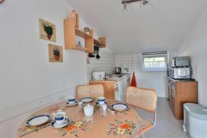 a kitchen with a table and chairs in a kitchen at FeWo Geranie in Kröpelin