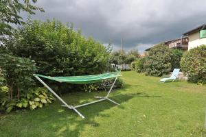 a hammock on the grass in a yard with a chair at FeWo Geranie in Kröpelin +7 photos