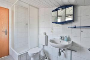 a white bathroom with a toilet and a sink at FeWo Geranie in Kröpelin