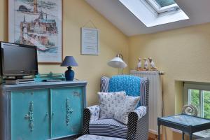 a living room with a chair and a tv on a cabinet at Herrenhaus Blengow App.18 in Blengow