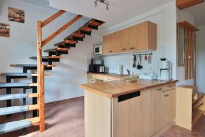a kitchen with a wooden counter and a spiral staircase at FeWo Hibiskus in Kröpelin +10 photos