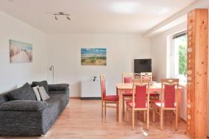 a living room with a table and chairs and a couch at FeWo Hibiskus in Kröpelin
