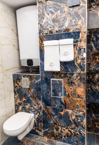 a bathroom with a toilet and a marble wall at Luxe 1 apartments in Obzor +77 photos