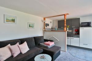 a living room with a couch and a kitchen at Bungalow Wolfgang in Kühlungsborn