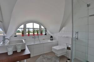 a white bathroom with a sink and a shower at FH Seeschwalbe in Niendorf +37 photos