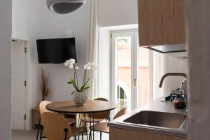 a kitchen with a table with a vase of flowers on it at Begani63 Boutique Apartments in Gaeta