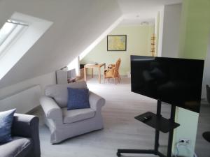 a living room with a flat screen tv and chairs at Wittenburg Perdöhl 2 in Wittenburg