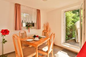 a dining room with a table and chairs and a window at Bungalow Koralle in Nienhagen