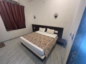 a bedroom with a bed and a red curtain at Mahendra place in Khātu