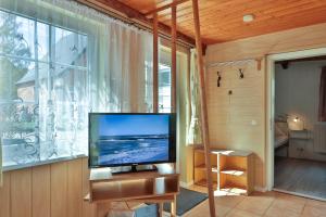 a flat screen tv sitting on a stand in front of a window at Waldblick 2 in Kühlungsborn