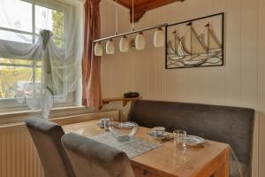 a dining room table and chairs with a wooden table and a window at Waldblick 2 in Kühlungsborn