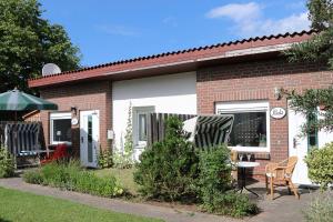 a small brick house with a table and chairs at Bungalow Paul in Nienhagen