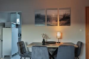 a dining room with a table and chairs and a refrigerator at Bungalow Paul in Nienhagen