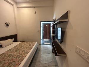 a bedroom with a bed and a tv in it at Mahendra place in Khātu +2 photos