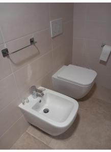 a bathroom with a white sink and a toilet at Casa Vacanze 9 Cavalieri in Maglie