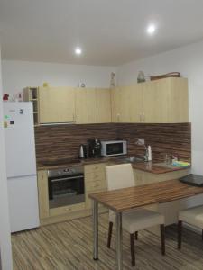 a kitchen with a table and a white refrigerator at Polyfunkční dům Pasát in Uherský Brod