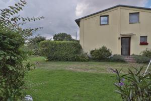 a house with a grass yard next to a building at FeWo Lavendel in Kröpelin
