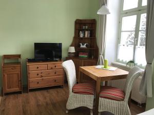 a living room with a wooden table and a television at Herrenhaus Blengow App.1 in Blengow