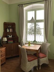a dining room table with two chairs and a window at Herrenhaus Blengow App.1 in Blengow