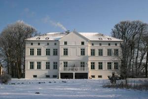 a large white house with snow on the ground at Herrenhaus Blengow App.1 in Blengow +13 photos