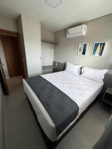 a bedroom with a large bed with white sheets at Apartamento Ipioca Beach Life - Maceió in Maceió