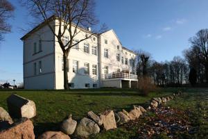 a large white house with rocks in front of it at Herrenhaus Blengow App.03 in Blengow