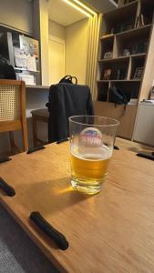 a glass of beer on a table with a remote control at Apartamento Ipioca Beach Life - Maceió in Maceió