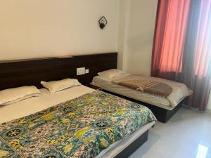 two beds in a small room at Mahendra place in Khātu