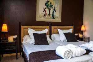 a bedroom with two beds with towels on them at Termes Montbrio Hotel & Spa in Montbrió del Camp