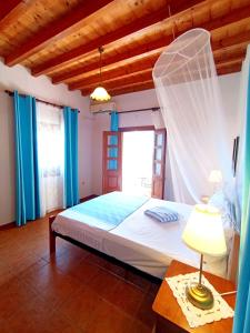 a bedroom with a bed with a mosquito net at Patmos Garden Sea in Grikos