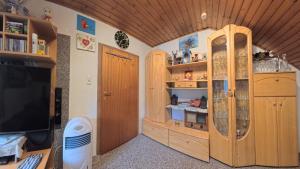 a room with wooden cabinets and a television at Ferienwohnung Ri-Wo in Malta
