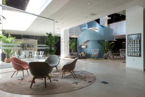 a lobby with chairs and tables in a building at Elite Hotel Ideon, Lund in Lund