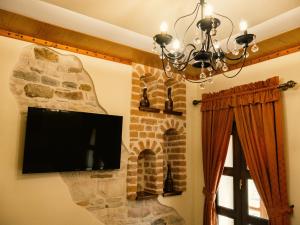 a flat screen tv hanging on a stone wall at Hotel SS KEKEZI in Gjirokastër