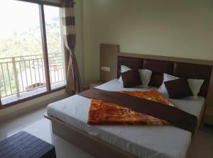 a bedroom with a bed with a large window at Skoon b&b homestay in Shimla