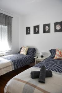 a bedroom with two beds and pictures on the wall at El Racó de la Vero in Falset