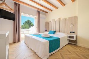 a bedroom with a large bed and a television at azuLine Apartamentos Can Sanso in Santa Eularia des Riu +16 photos