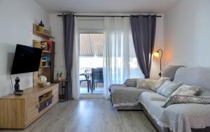 a living room with a couch and a television at El Racó de la Vero in Falset