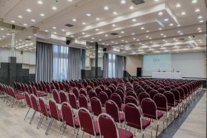 a lecture hall with red chairs and a screen at Capsis Hotel Thessaloniki in Thessaloniki +118 photos