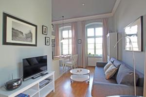a living room with a couch and a tv at Herrenhaus Blengow App.02 in Blengow