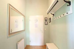a hallway with a white door and a mirror at Herrenhaus Blengow App.02 in Blengow