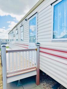 a mobile home with a porch and a railing at 6 Birth Cosy caravan 134 Sealands in Ingoldmells