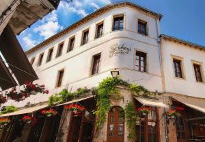 a large white building with flowers on it at Hotel SS KEKEZI in Gjirokastër