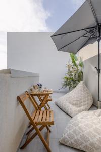a chair and an umbrella on a balcony at Sarakina Urban Grace in Stone by 8essentially in Heraklio