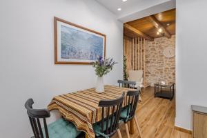 a dining room table with chairs and a vase of flowers on it at Sarakina Urban Grace in Stone by 8essentially in Heraklio
