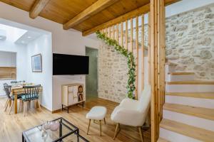 a living room with a staircase and a table and chairs at Sarakina Urban Grace in Stone by 8essentially in Heraklio